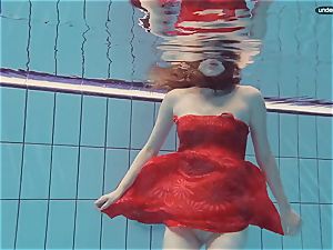 crimson clothed nubile swimming with her eyes opened